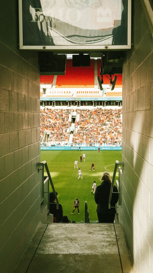 A photo I took from the tunnel leading to my seat at the inaugural AFC Toronto game at BMO Field on April 19, 2025. The field is visible framed between the tunnel walls, with a large crowd of fans in the stands.