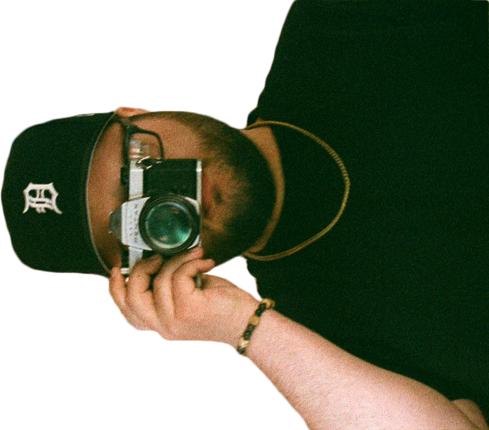 A self-portrait of myself in a mirror, looking through the viewfinder of a Pentax K1000 film camera.