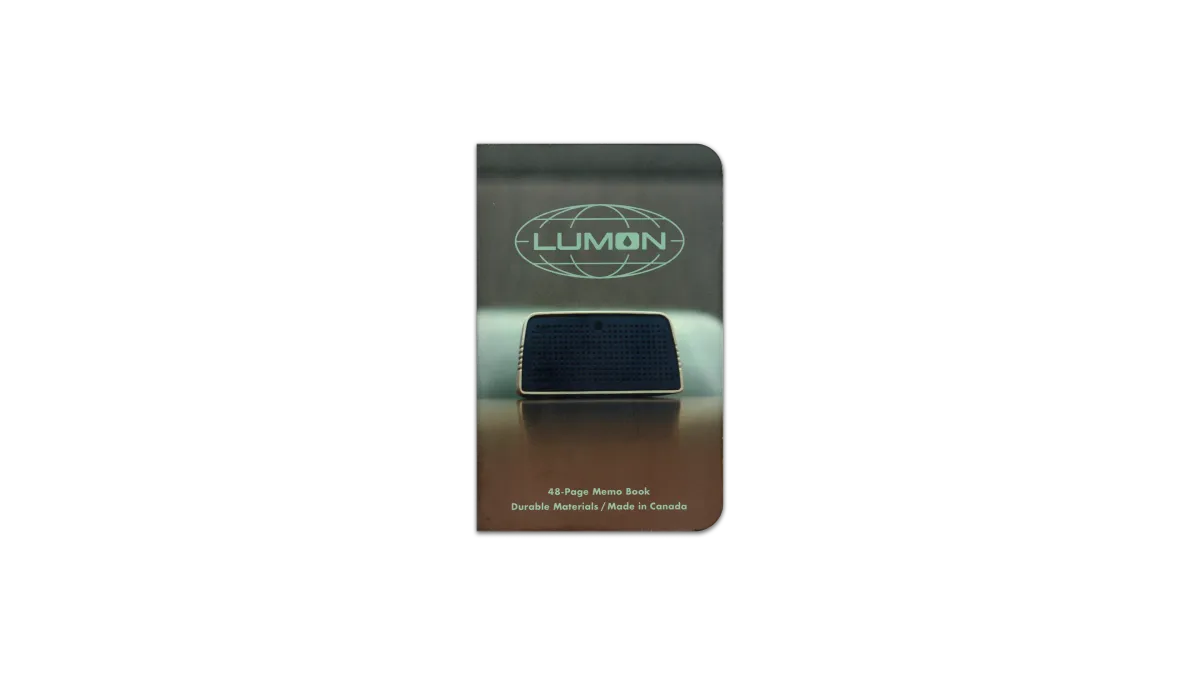 A digital scan of the cover of the journal I used during April, 2025. It is a custom MIKIE NOTES ‘Lumon Industries’ edition, featuring an image of a conference speaker on a desk, from a episode of Severance, Season 1.